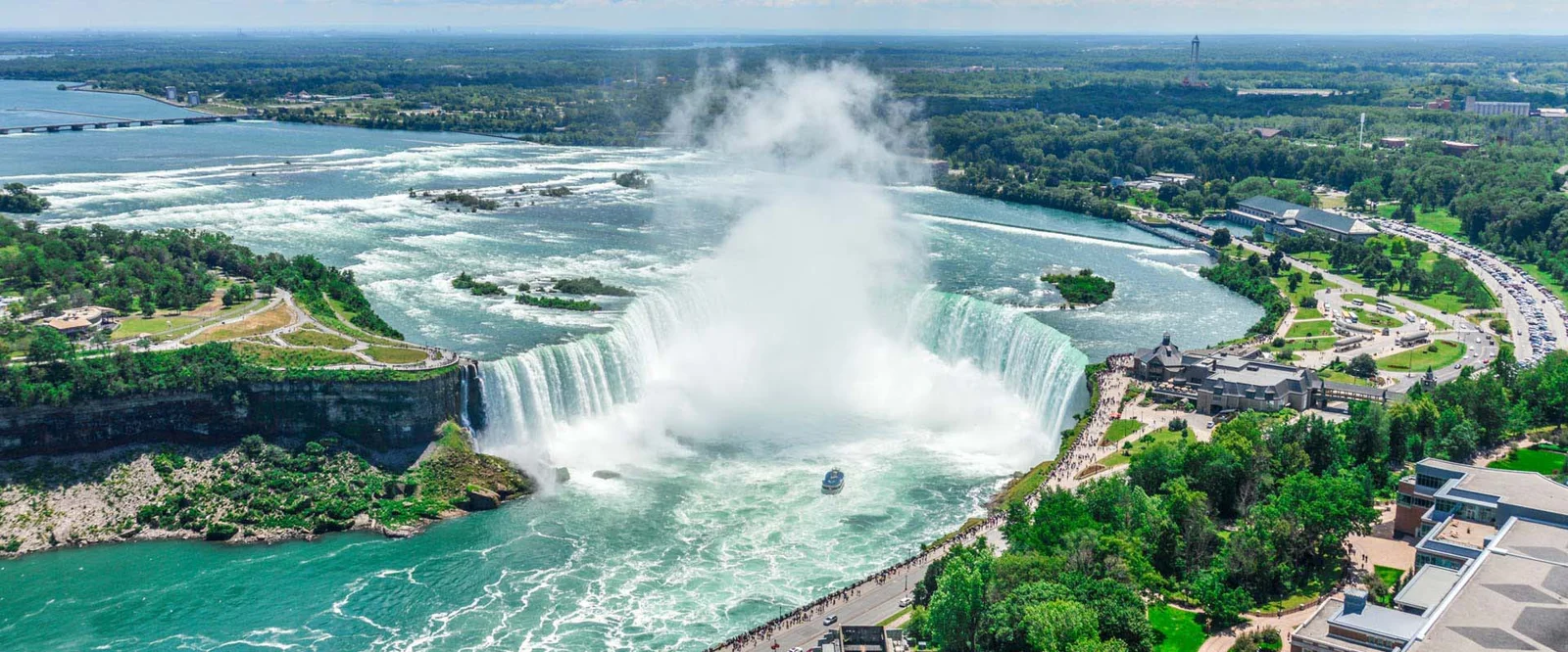 A Niagara City Cruises tour boat sailing into the rising mist at the base of the Horseshoe Falls on the Canadian side of Niagara